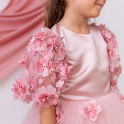 Blush satin flower girl dress showing smooth satin bodice and sheer floral appliqué sleeve with soft pearl accents