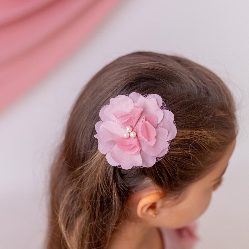 Blush pink floral hair accessory with pearl details, designed to complement a flower girl dress for weddings and special occasions