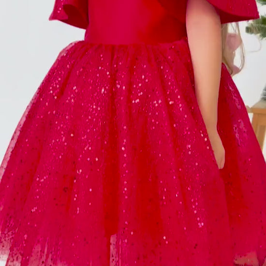 Red satin flower girl dress shown in motion with layered tulle skirt and elegant silhouette

