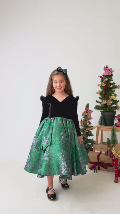Video showing emerald green velvet flower girl dress in motion with full skirt and styling details

