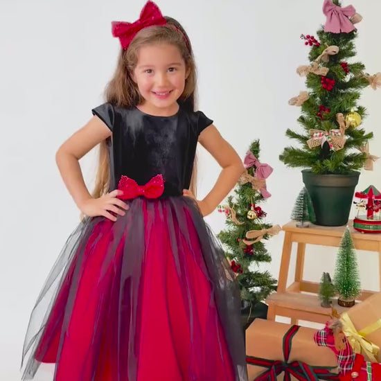 Video showing red and black velvet flower girl dress in motion with layered tulle skirt and styling details
